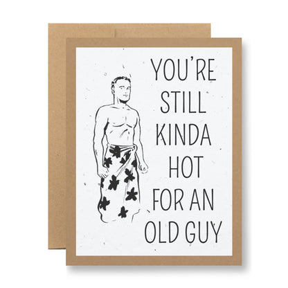 Introducing the "Plantable Greeting Card - You're still kinda hot for an old guy" from My Store, featuring an illustration of a shirtless man in a towel adorned with leaf patterns on handmade seed paper. The card carries the playful text, "You're still kinda hot for an old guy," and it comes with a recycled cardstock envelope, making it both cheeky and eco-friendly.