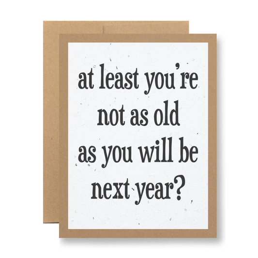 A plantable greeting card by My Store, made from recycled cardstock, displays the message "At least you're not as old as you will be next year?" in bold black font on a white background, complemented by a brown border and envelope.