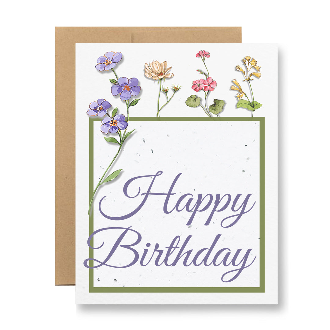 The "Plantable Greeting Card - Happy Birthday {wildflower frame}" by My Store is beautifully designed with the words "Happy Birthday" in elegant script, printed on wildflower seed embedded paper. It showcases vibrant illustrations of flowers at the top and left side, complemented by a brown envelope crafted from recycled cardstock.