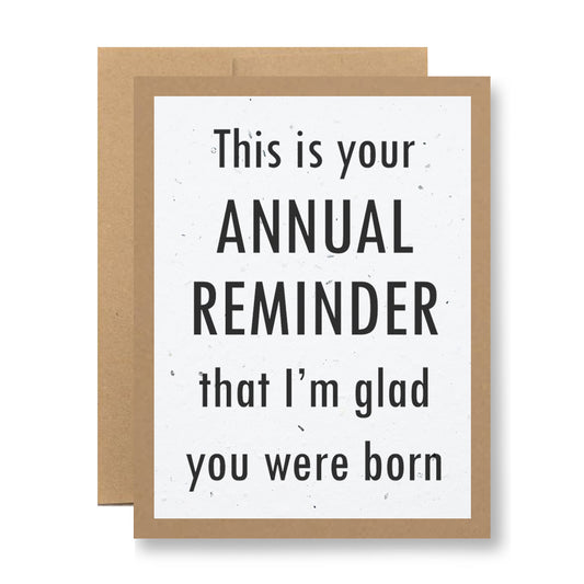 Introducing the Plantable Greeting Card from My Store, featuring a kraft paper border and made from recycled cardstock. The card displays the message: "This is your ANNUAL REMINDER that I’m glad you were born" in bold and regular fonts.