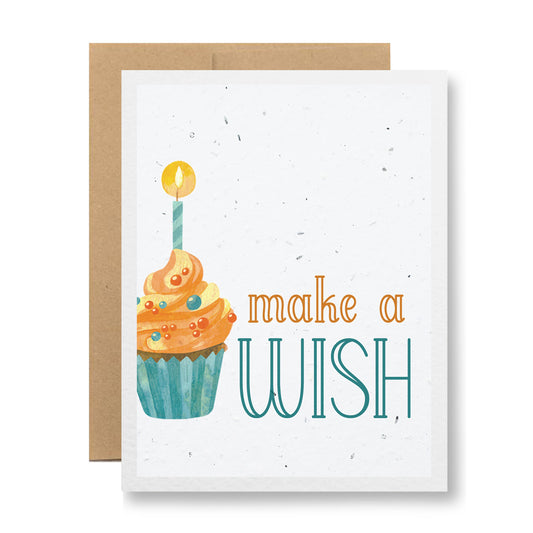 Introducing the "Plantable Greeting Card - Make a wish" by My Store, featuring a vibrant cupcake with a lit candle on handmade seed paper. The card simply yet cheerfully displays "make a WISH" in bold letters and comes with an eco-friendly plain brown envelope made from biodegradable materials.