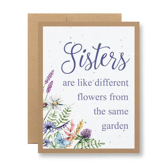 My Store presents the Plantable Greeting Card - ...from the same garden, featuring a heartfelt message: "Sisters are like different flowers from the same garden." This card is crafted on biodegradable material and showcases a delicate, colorful floral design reminiscent of wildflower seeds, elegantly bordered by a charming brown frame.