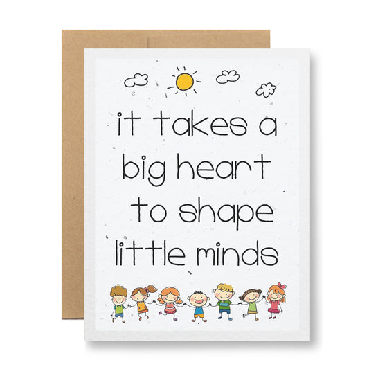 The "Plantable Greeting Card - It takes a big heart..." by My Store is made from biodegradable, handmade seed paper and showcases an illustration of nine smiling children holding hands at the bottom. The card features the message, "It takes a big heart to shape little minds," with a sun and clouds above that will sprout wildflower seeds when planted.